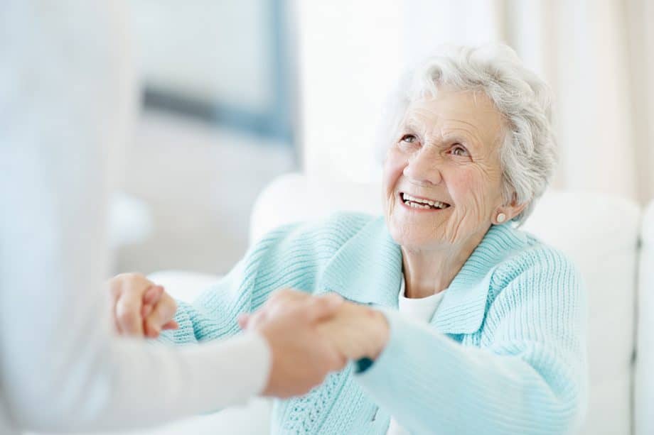 happy senior woman getting help standing up